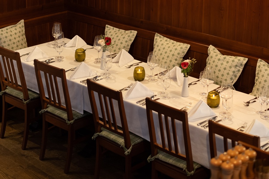 Tischgedeck im Restaurant mit weißer Tischdecke, Gläsern und Dekorationselementen