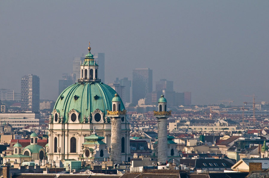 Prominent dome with turquoise roof and twin towers against hazy skyline in Vienna